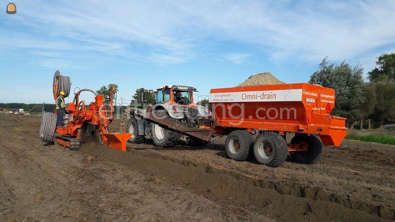 Traktor met zandkar voorzien van transportbandsysteem