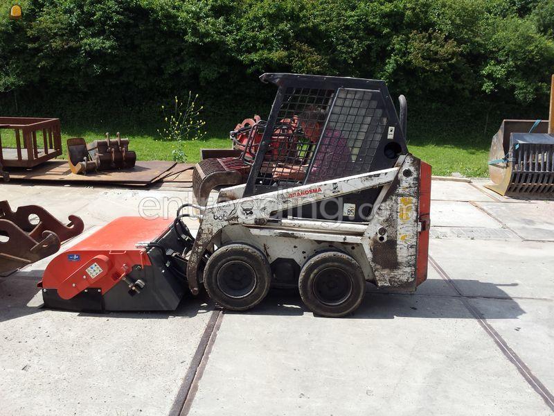 Bobcat met veegbezem en opvangbak