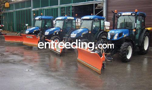 Tractor met sneeuwschuif en zoutstrooier