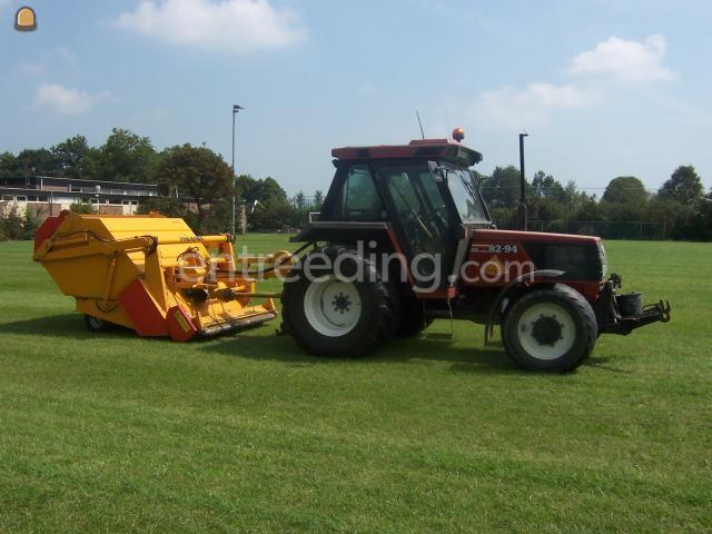 Tractor met grasveegmachine