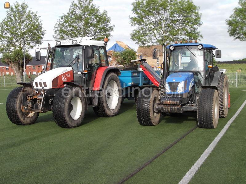 Tractor + rubber/infill uithaalmachine