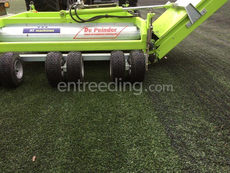 Tractor + rubber/infill uithaalmachine